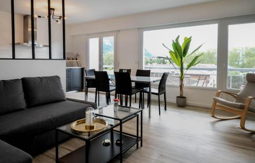 un salon avec un canapé et une table avec des chaises dans l'établissement Hysope, à Annecy