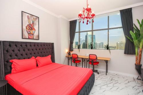 - une chambre avec un lit rouge et une table avec des chaises dans l'établissement Dubai Downtown French Chic Apartment, à Dubaï