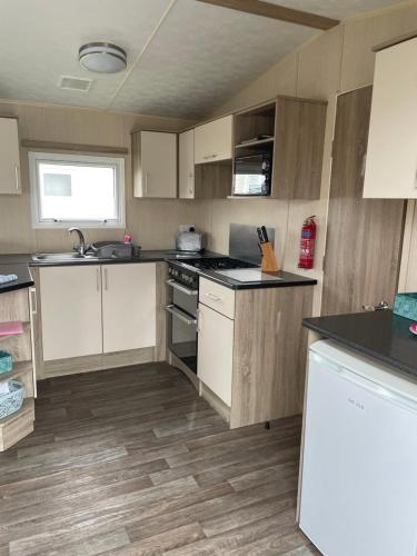 a kitchen with white cabinets and black counter tops at 9 shearwater Tattershall Lakes Country Park in Tattershall