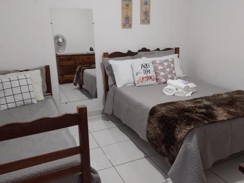 a bedroom with a bed and a chair and a mirror at Casa Vista para Serra in Tiradentes
