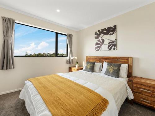 a bedroom with a large bed with a large window at Home Away From Home! in Auckland