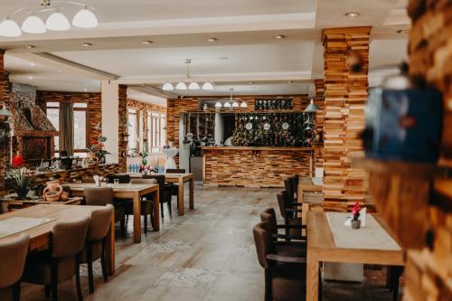 un restaurant avec des tables et des chaises et un mur en briques dans l'établissement Hotel Noor Konjic, à Konjic