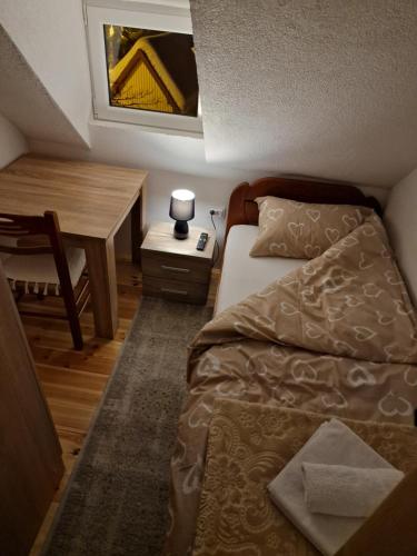 a small bedroom with a bed and a desk at Sobe Baranin Zabljak in Žabljak