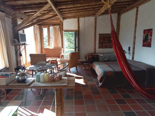 una sala de estar con una hamaca en una habitación en HOSTAL CASA DE GUADUA/ THE BAMBOO HOUSE, en Choachí