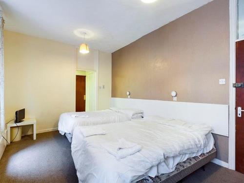 Zimmer mit 2 Betten und einem TV. in der Unterkunft Jini Hotel in Blackpool
