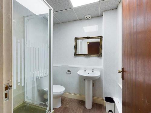 a bathroom with a toilet and a sink and a mirror at Jini Hotel in Blackpool