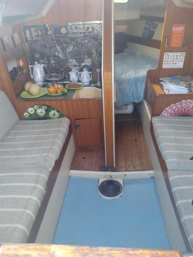 Cette petite chambre comprend un lit et une table dans un bateau. dans l'établissement super Voilier Eve, à Gruissan