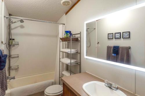een badkamer met een wastafel, een toilet en een spiegel bij Lakefront Many Vacation Home with Kayaks! in Many