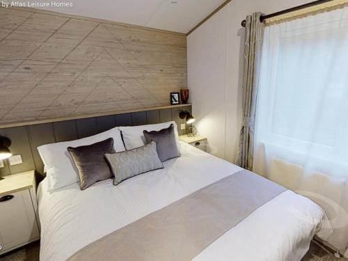 a bedroom with a large white bed with two pillows at Sherwood Lodge in Cheddar