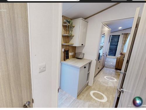 uma cozinha com armários brancos e um frigorífico branco em Sherwood Lodge em Cheddar