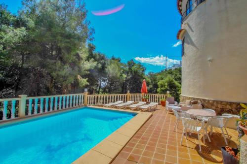 a swimming pool with chairs and a fence at Monica II - holiday home with private swimming pool in Benissa in Benissa