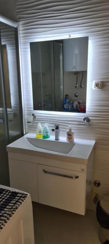 a bathroom with a white sink and a mirror at Apartment Mini in Kumanovo