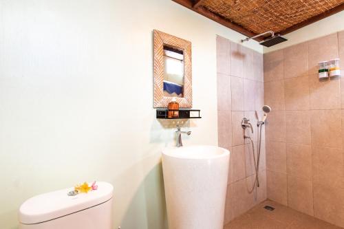 uma casa de banho com um WC e um chuveiro com um espelho. em Nusa Penida Yurt em Nusa Penida
