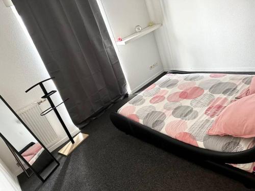 - une chambre dotée d'un lit avec des draps roses et gris dans l'établissement Appartement t2 au chartrons, à Bordeaux
