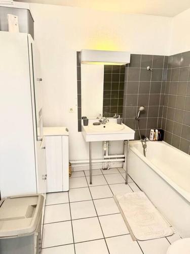 uma casa de banho com um lavatório, uma banheira e um WC. em Appartement t2 au chartrons em Bordéus