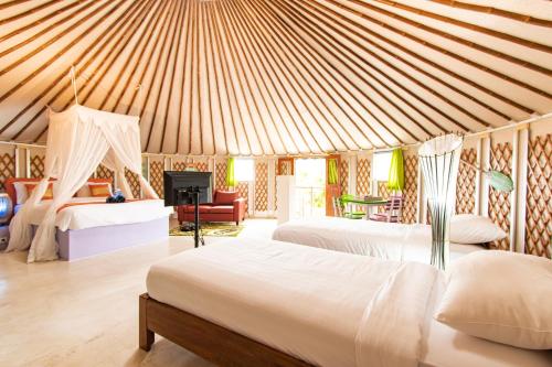 a bedroom with two beds and a fireplace at Nusa Penida Yurt in Nusa Penida