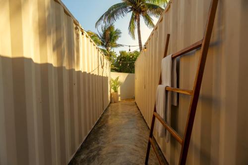 a hallway of a building with a palm tree in the distance at Alquimia Hotel Boutique in Tulum