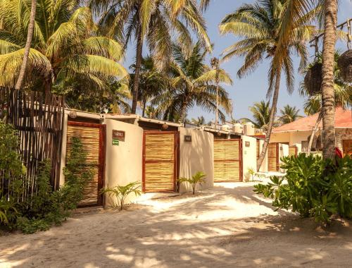 a row of wooden garage doors in front of palm trees at Alquimia Hotel Boutique in Tulum