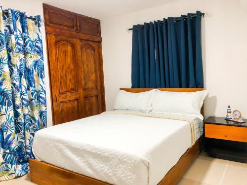 een slaapkamer met een bed en een blauw gordijn bij Ocean View Apart. In Down town in San Felipe de Puerto Plata
