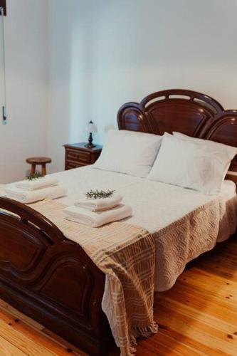 a bedroom with a large wooden bed with white pillows at Casa Manjerico in Loulé