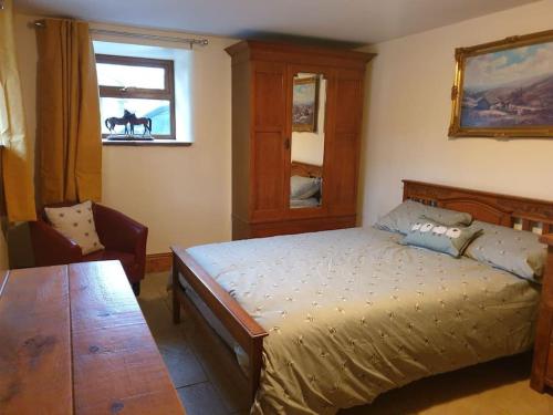 a bedroom with a bed and a table and a window at The Coach House in Baxenden