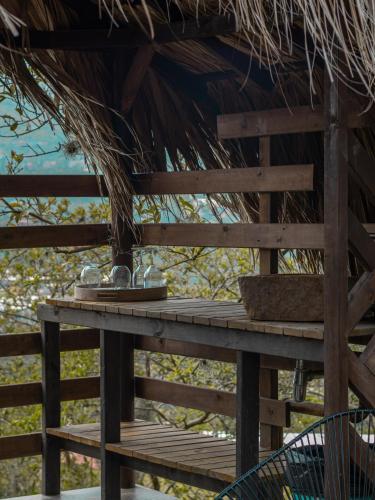 a wooden deck with a thatch roof at All Natural Glamping in Copacabana