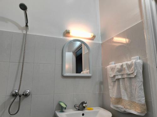 ein Bad mit einem Waschbecken, einem Spiegel und einer Dusche in der Unterkunft Appartement calme et confortable in Al Ghar