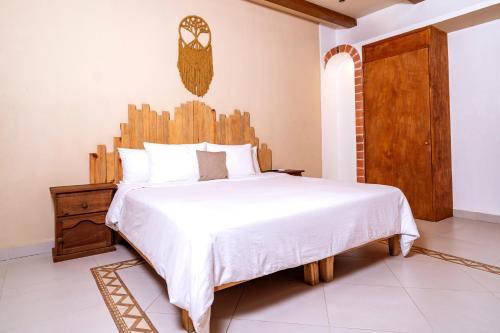 a bedroom with a bed with a wooden headboard at Mezcal Hotel in Cancún