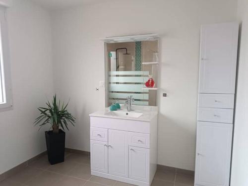 bagno bianco con lavandino e specchio di Chambre privée a Montaigu-Vendée