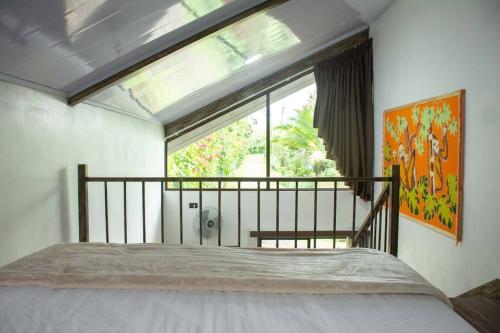 a bedroom with a bed and a large window at Tinny House in La Fortuna #1 in Fortuna