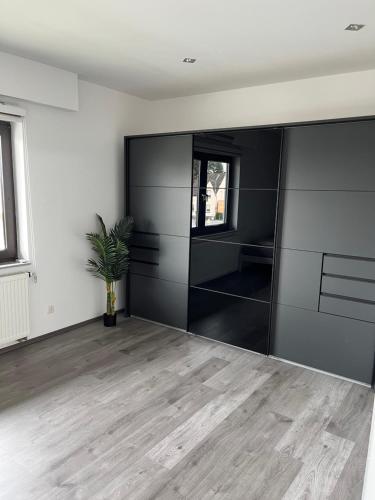 a living room with black cabinets and a potted plant at Messewohnung/Ferienwohnung in Cologne