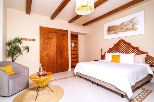 een slaapkamer met een bed en een stoel bij Mezcal Hostel in Cancun
