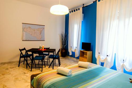 1 dormitorio con 1 cama y 1 mesa con sillas en Naxos Sea Holiday Apartments, en Giardini Naxos