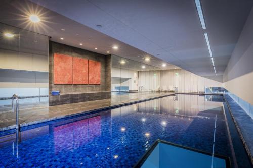 a large swimming pool in a building with a pool at Fraser Suites Sydney in Sydney