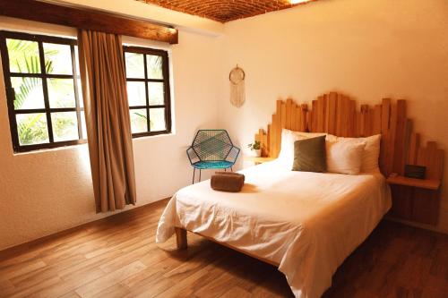 a bedroom with a bed and a chair in it at Mezcal Hotel in Cancún