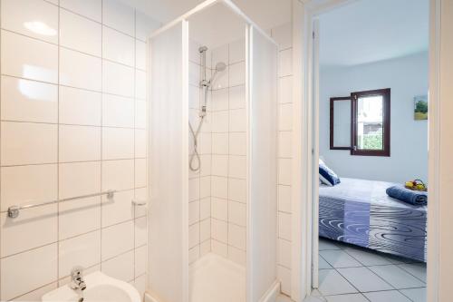 a bathroom with a shower and a toilet and a bed at Le tre sirene in Porto Cesareo