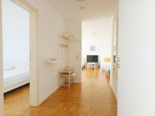 a hallway with a bed and a room with a television at Sonniges 2-Zimmer-Gartenapartment in Bietigheim-Bissingen