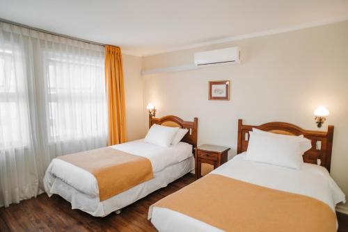 a hotel room with two beds and a window at Hotel Melillanca in Valdivia