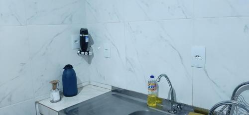 uma cozinha com um lavatório e um telefone na parede em Quarto Suite na Gavea no Rio de Janeiro