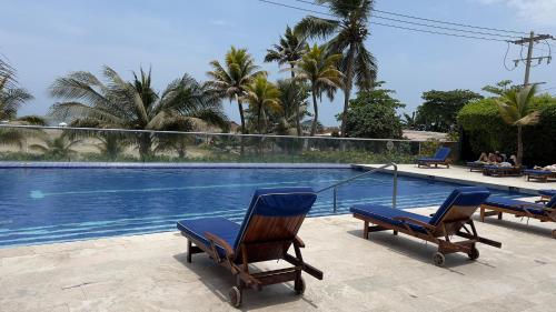 a couple of chairs sitting next to a swimming pool at Apartamento Cartagena in Cartagena de Indias