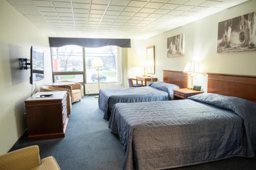 um quarto de hotel com duas camas e uma janela em Hôtel Motel Le Voyageur em Saint-Georges
