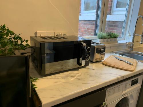 a microwave sitting on top of a kitchen counter at Heaton-Beautiful 3 Double Bedrooms Sleeps 6 Free Parking and Wifi in Newcastle upon Tyne