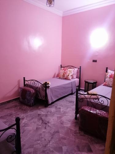 2 łóżka w pokoju z fioletowymi ścianami w obiekcie Le bel abri w mieście Meknès