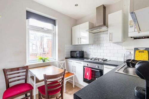 a kitchen with a table and chairs and a counter top at Comfy Friendly Stay in London