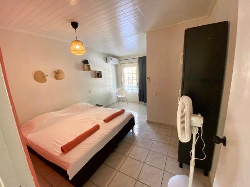 a bedroom with a bed and a fan in it at Casa Augusto in Willemstad