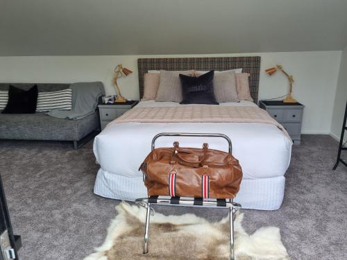 een slaapkamer met een bed met een bruine tas op een tafel bij Alto on hedditch in Wanaka