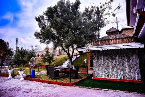a building with a table and chairs in a yard at Republika Central Hotel & Resort in Abbottābād