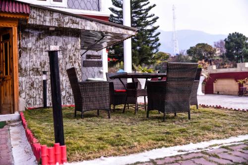 a group of chairs sitting outside of a house at Republika Central Hotel & Resort in Abbottābād
