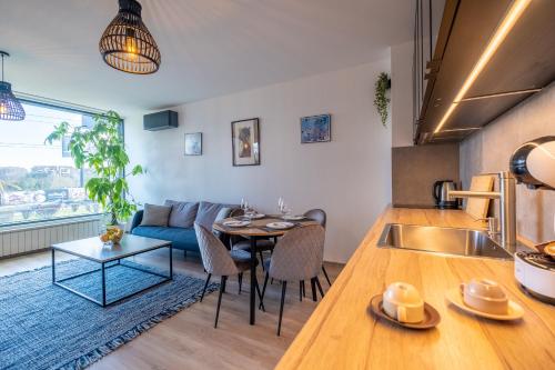 a kitchen and living room with a table and a couch at Arcadia Apartment, Park and Parking in Sofia