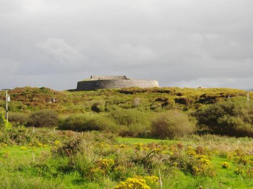 a stone building on top of a grassy hill at The Blue Door Apartment in Cahersiveen